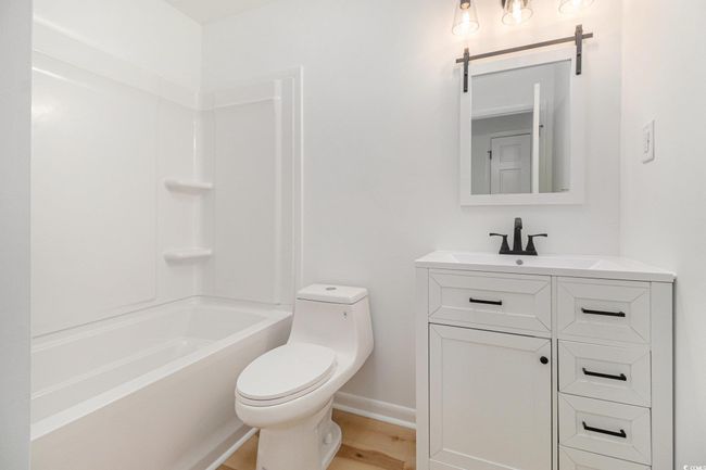 Full bath featuring vanity, shower / bath combination, and luxury vinyl plank floors. LED light exhaust fan has WIFI capability to enjoy music or your favorite podcast while you shower! | Image 27
