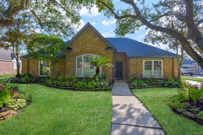 Mature trees shade the entry with lush foliage welcoming you to the home. | Image 1