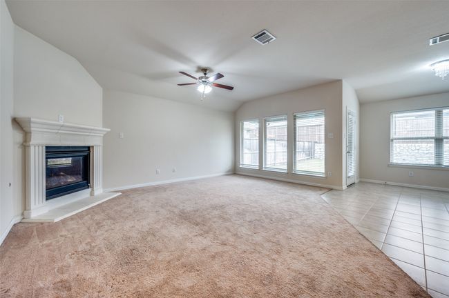 Living room with healthy amount of natural light, ceiling fan and a fireplace | Image 4