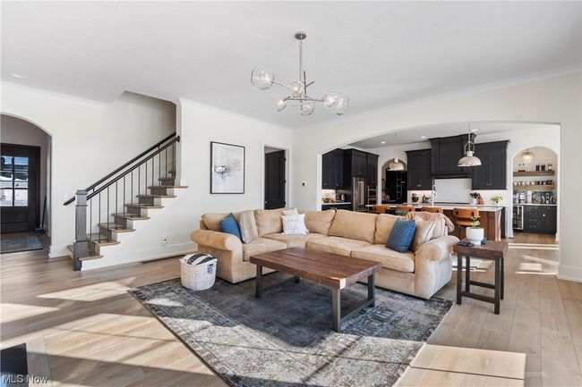 Living room featuring wood flooring, a chandelier, and crown molding | Image 7