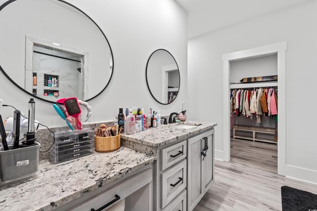 Bathroom with vanity, wood finished floors, a walk in closet, and a shower | Image 20