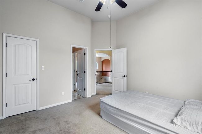 Carpeted bedroom with high vaulted ceiling, arched walkways, baseboards, and ceiling fan | Image 26