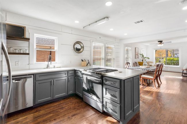 Kitchen featuring stainless steel appliances, gray cabinets, backsplash, a peninsula, and recessed lighting | Image 14