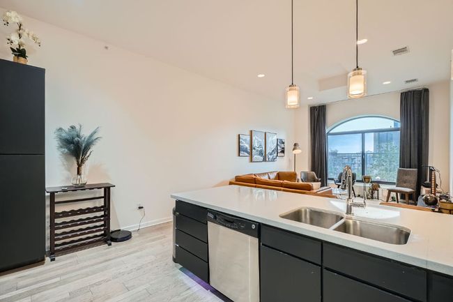 Kitchen with light countertops, a sink, light wood-style floors, visible vents, and dishwasher | Image 9