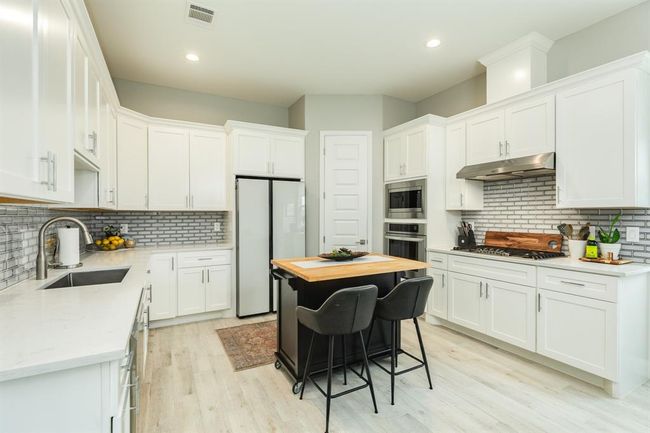 The kitchen, an integral part of thishome's open-concept design, seamlessly flows off the dining room, creating a harmonious andconnected living space. | Image 16