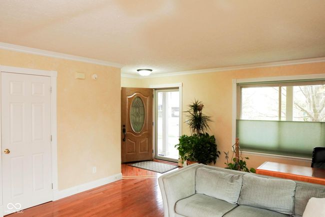living room featuring baseboards, ornamental molding, and wood finished floors | Image 5