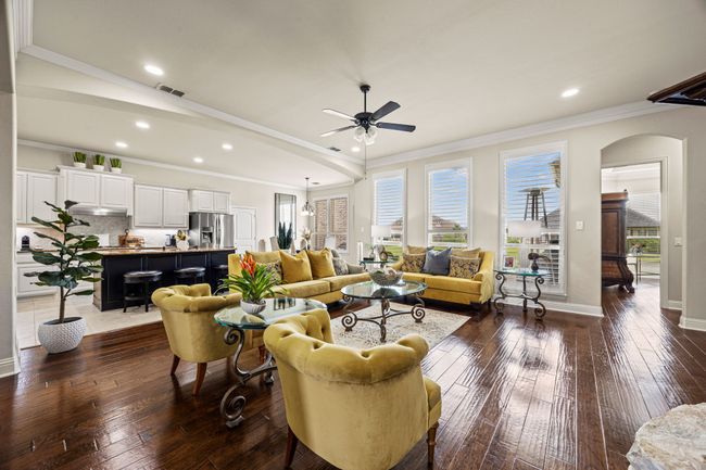 Living room featuring ceiling fan, dark wood finished floors, arched walkways, recessed lighting, and crown molding | Image 6