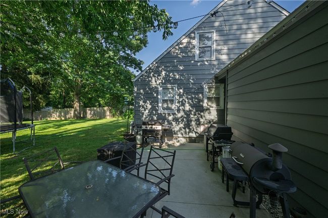 View of patio featuring a trampoline, area for grilling, and outdoor dining area | Image 5