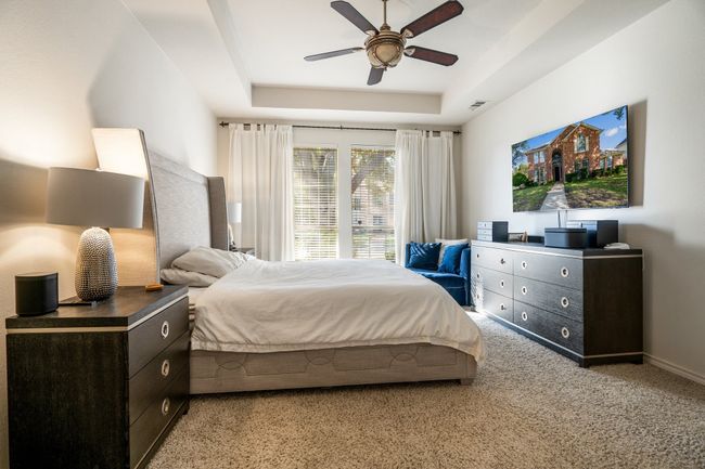 Bedroom featuring a raised ceiling, visible vents, a ceiling fan, and light colored carpet | Image 15
