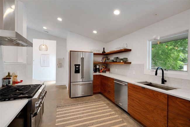 Kitchen featuring stainless steel appliances, a professional gas range, and quartz countertops. | Image 7