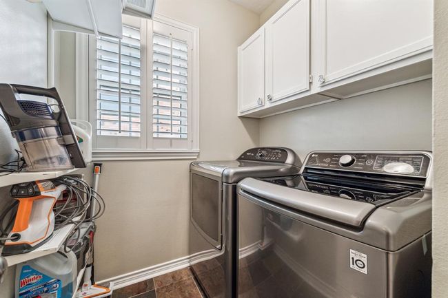 Conveniently located by the kitchen, this laundry room offers ample storage. | Image 16