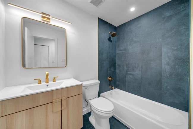 Full bath featuring toilet, vanity, shower / tub combination, and tile patterned floors | Image 22
