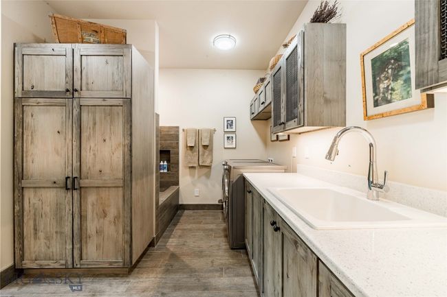 Main level laundry room with sink and reclaimed wood cabinetry. | Image 33