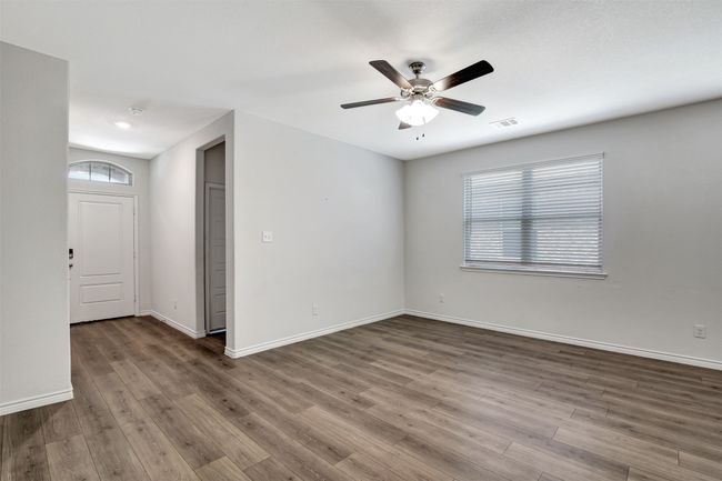 Empty room with wood finished floors, ceiling fan, and a smoke detector | Image 26