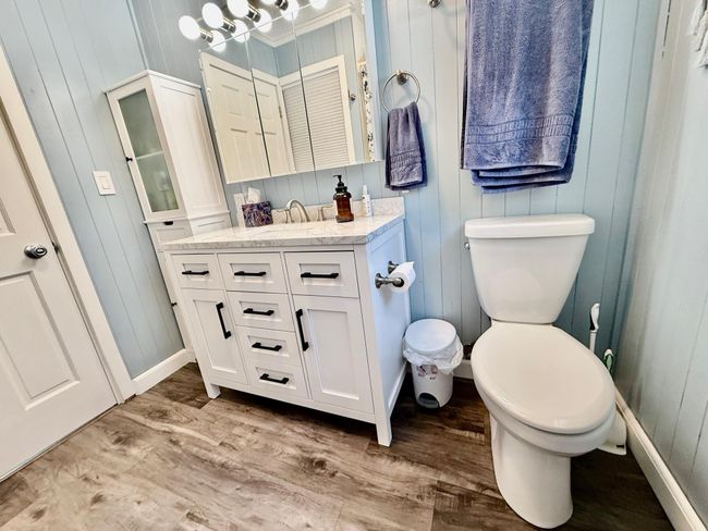 Just finished main level full bath with extra deep tub, new flooring, gorgous solid surface vanity, toilet, storage cabinet, medicine cabinet and lighting. | Image 10