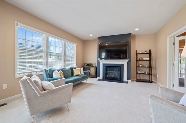 The large family room includes a gas fireplace and large windows that offer plenty of natural light. | Image 7