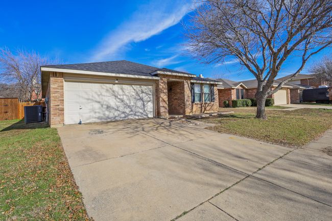 Single story home with central AC unit, a front lawn, and a garage | Image 20