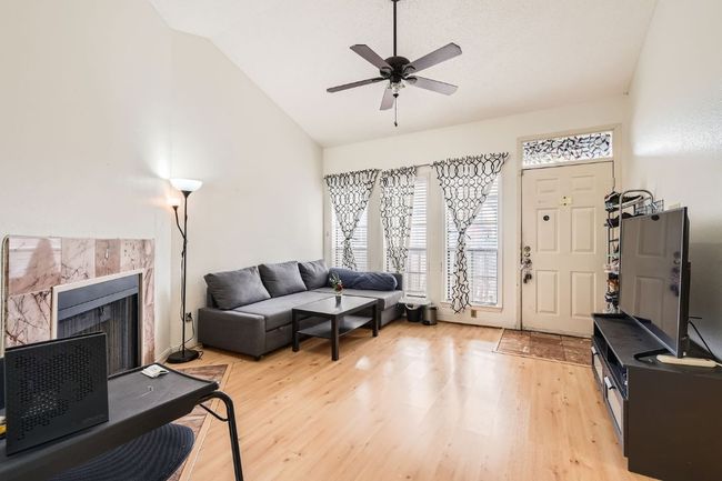 Living area with a ceiling fan, a tile fireplace, light wood-style flooring, and vaulted ceiling | Image 6