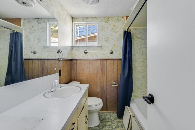 Bathroom with toilet, wainscoting, vanity, a textured ceiling, and wallpapered walls | Image 11