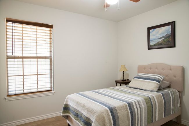 Bedroom with wood finished floors and a ceiling fan | Image 16
