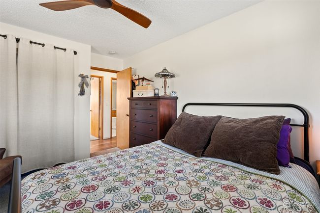 A second view of the main floor's second bedroom highlights its spacious layout and versatility. This cozy and well-lit room offers ample potential for creating a comfortable and personalized retreat | Image 19