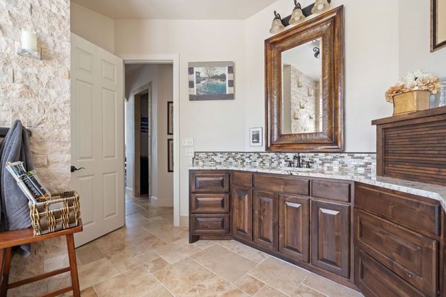 Bathroom featuring decorative backsplash, vanity, and stone finish flooring | Image 17