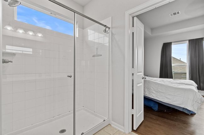 Ensuite bathroom with a stall shower, plenty of natural light, wood finished floors, and baseboards | Image 20