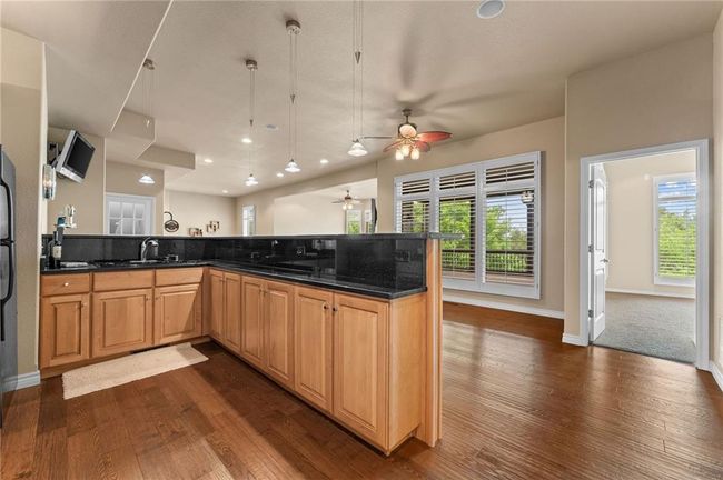Kitchen featuring a sink, dark wood-style floors, ceiling fan, and a peninsula | Image 39