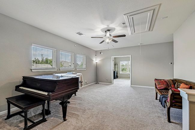 Family room with attic access, light carpet, and ceiling fan | Image 22