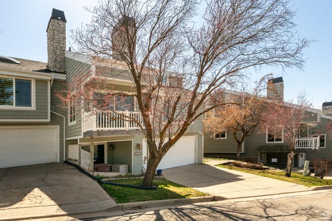 View of front of house featuring a balcony, driveway, a chimney, and an attached garage | Image 4