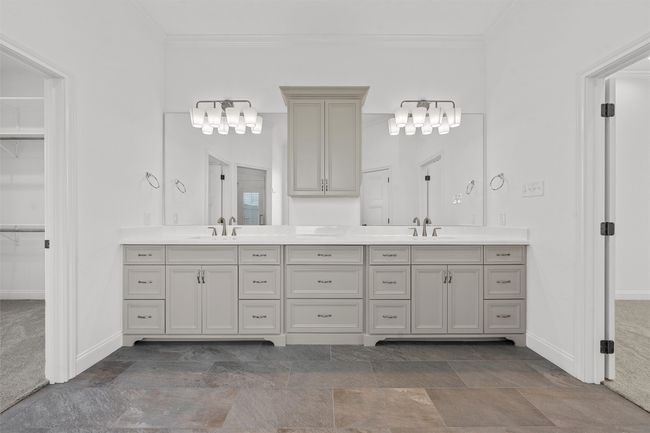 Bathroom with double vanity, crown molding, a walk in closet, and a chandelier | Image 20