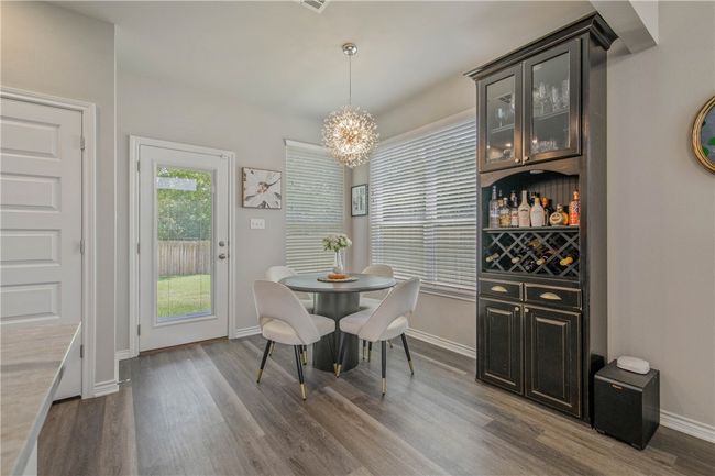 Dining area with dark wood finished floors and a chandelier | Image 9
