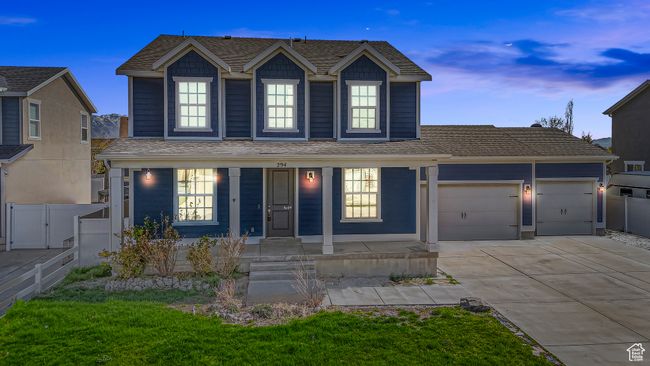 Traditional-style home featuring concrete driveway, a garage, a shingled roof, and fence | Image 51