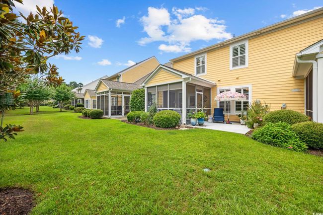 Back of property with a sunroom, a patio area, and a lawn | Image 25