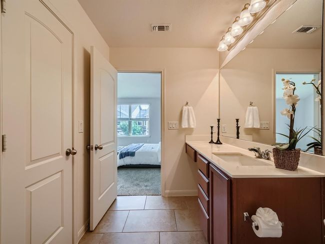 Ensuite bathroom with vanity, baseboards, and tile patterned flooring | Image 9