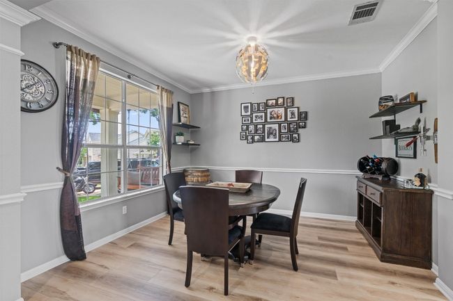 Dining space featuring chandelier, ornamental molding, & crown molding | Image 5