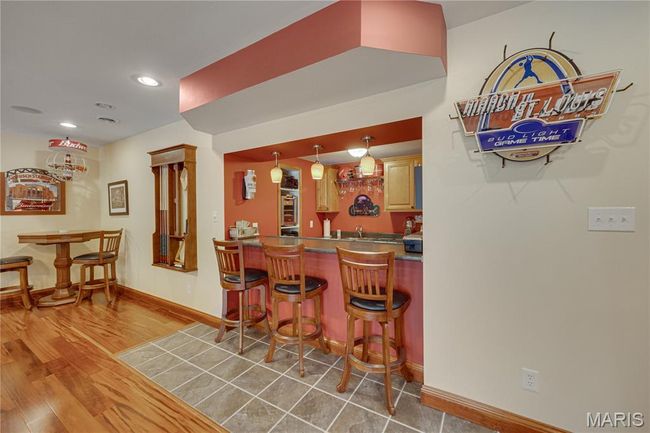 Indoor wet bar with wood finished floors, recessed lighting, and decorative light fixtures | Image 49