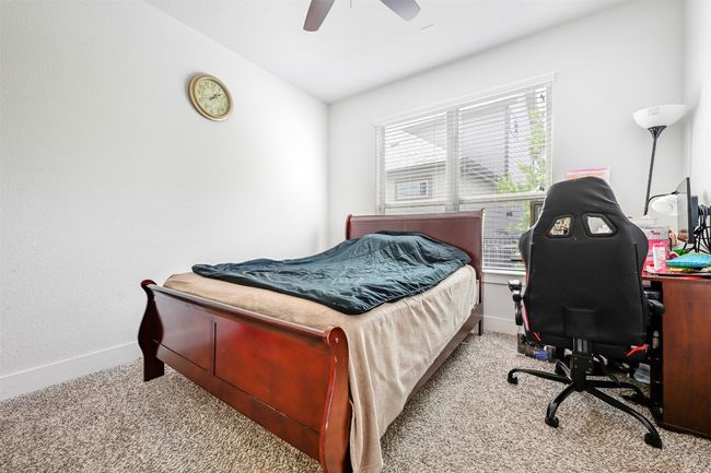 Carpeted bedroom with a desk, a ceiling fan, and lofted ceiling | Image 25
