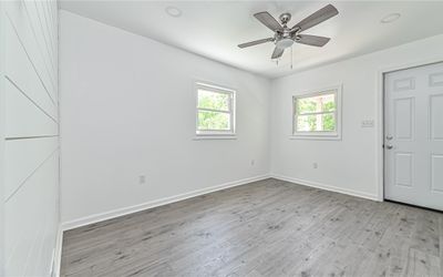 Living room features recessed lighting and ceiling fan with overhead lighting. | Image 3