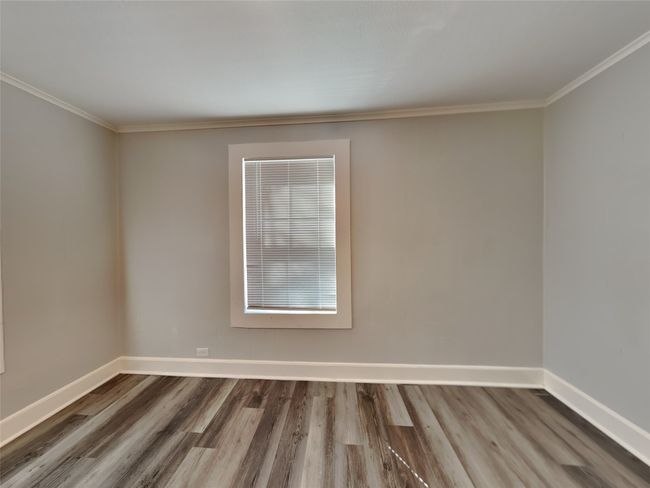 Spare room featuring wood finished floors, baseboards, and ornamental molding | Image 8