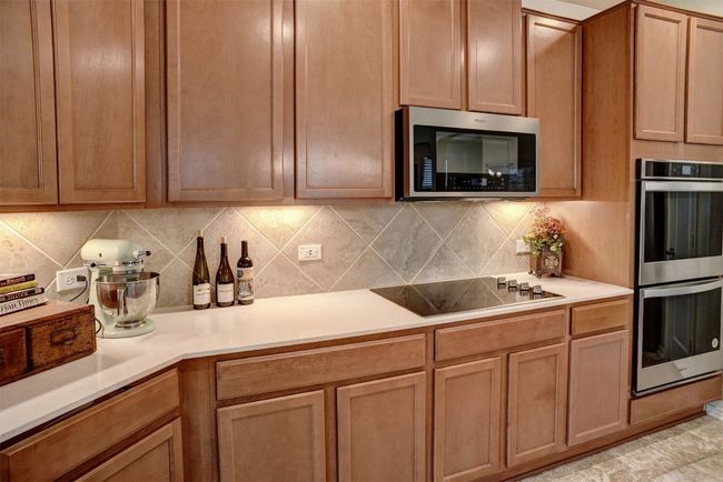 Kitchen featuring appliances with stainless steel finishes, tasteful backsplash, and light countertops | Image 22