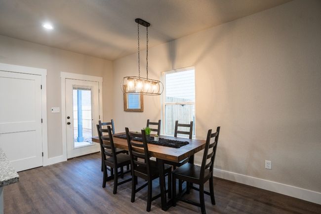 Dining space featuring dark wood-style floors, baseboards, and a chandelier | Image 6