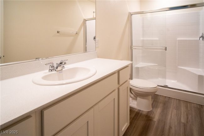 Bathroom with plank vinyl floors, vanity, and a stall shower | Image 13