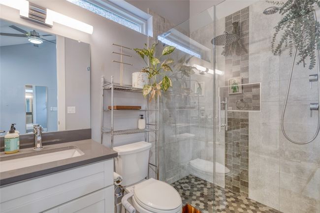 Full bath featuring vanity, a stall shower, toilet, and a ceiling fan | Image 10