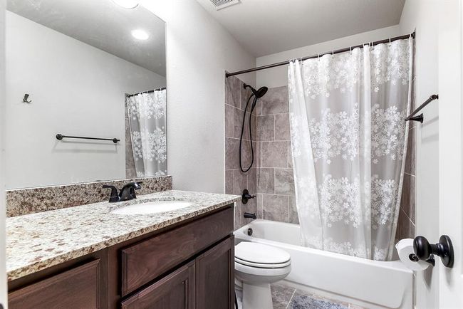 The upstairs bedroom features a private attached bathroom, complete with a large vanity sink and a shower-tub combo. This well-appointed bathroom offers both functionality and comfort, complementing the spacious bedroom. | Image 33