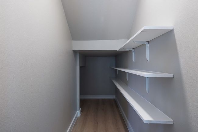 Walk in closet with dark wood-type flooring | Image 16