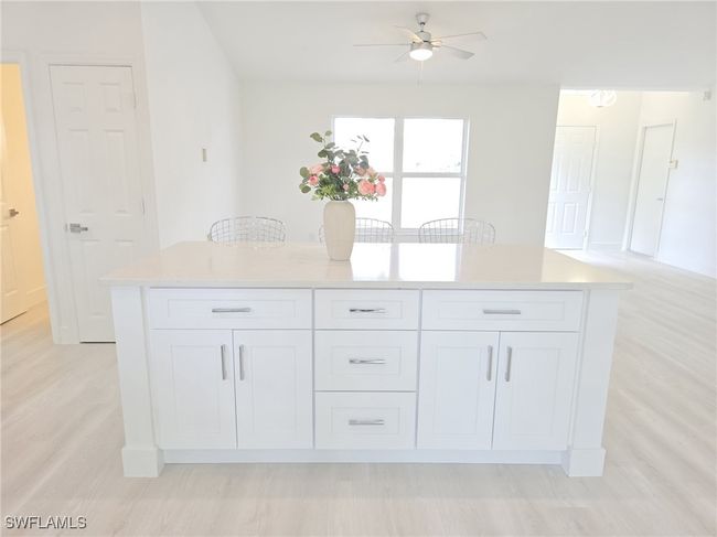 Kitchen featuring white cabinetry, a ceiling fan, light countertops, and light wood-type flooring | Image 18