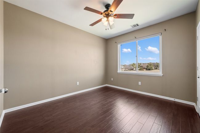 Spare room 2 featuring wood floors, ceiling fan, and walk in closet | Image 26