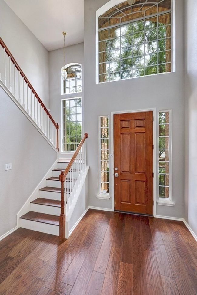 Entrance foyer with a towering ceiling, stairway, hardwood / wood-style flooring, healthy amount of natural light, and baseboards | Image 4