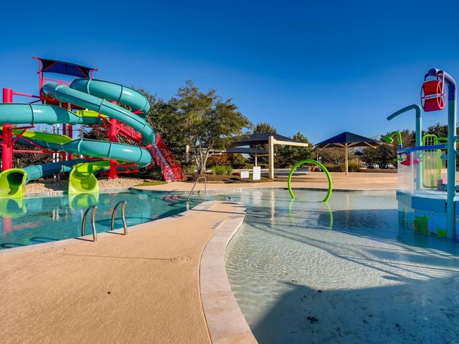One of two pool areas, this is where the kids have FUN! A splash pad and slide will be sure to delight even the littlest of kiddos. On-site lifeguards make relaxing a lot easier. | Image 34